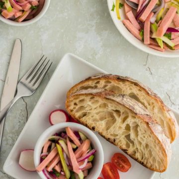 一碗Wurstsalat搭配丰盛的面包的一面切西红柿