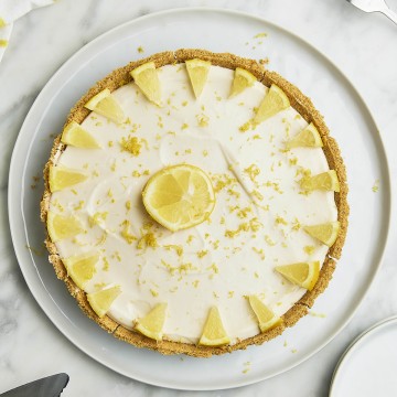 自顶向下的柠檬芝士蛋糕装在一个白色的托盘。